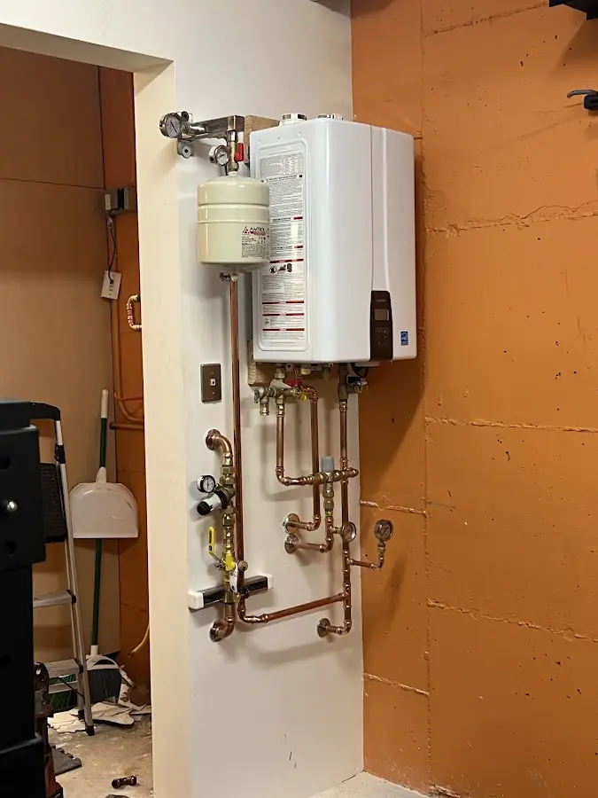 Plumbing technician inspecting water heater connections in Alsip